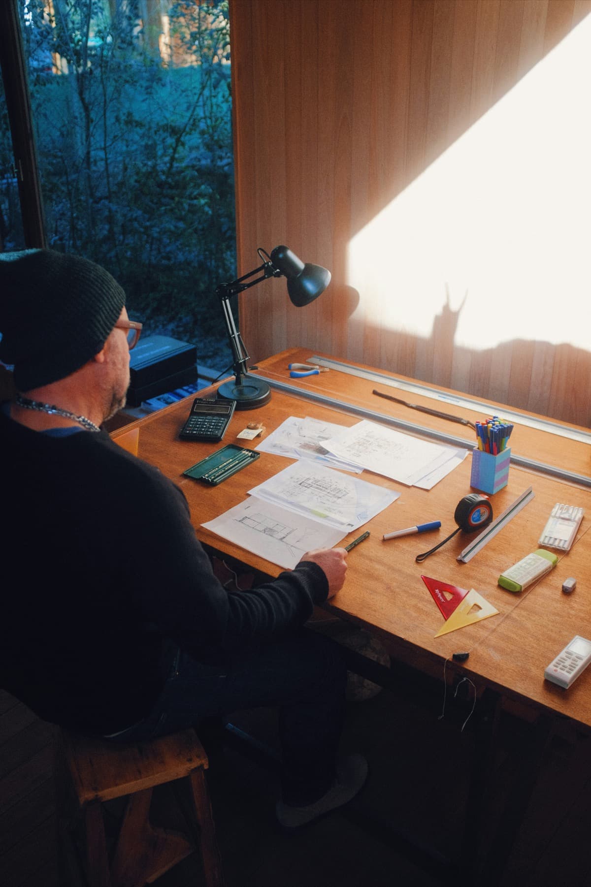 Architect working at a desk with drawings and project notes