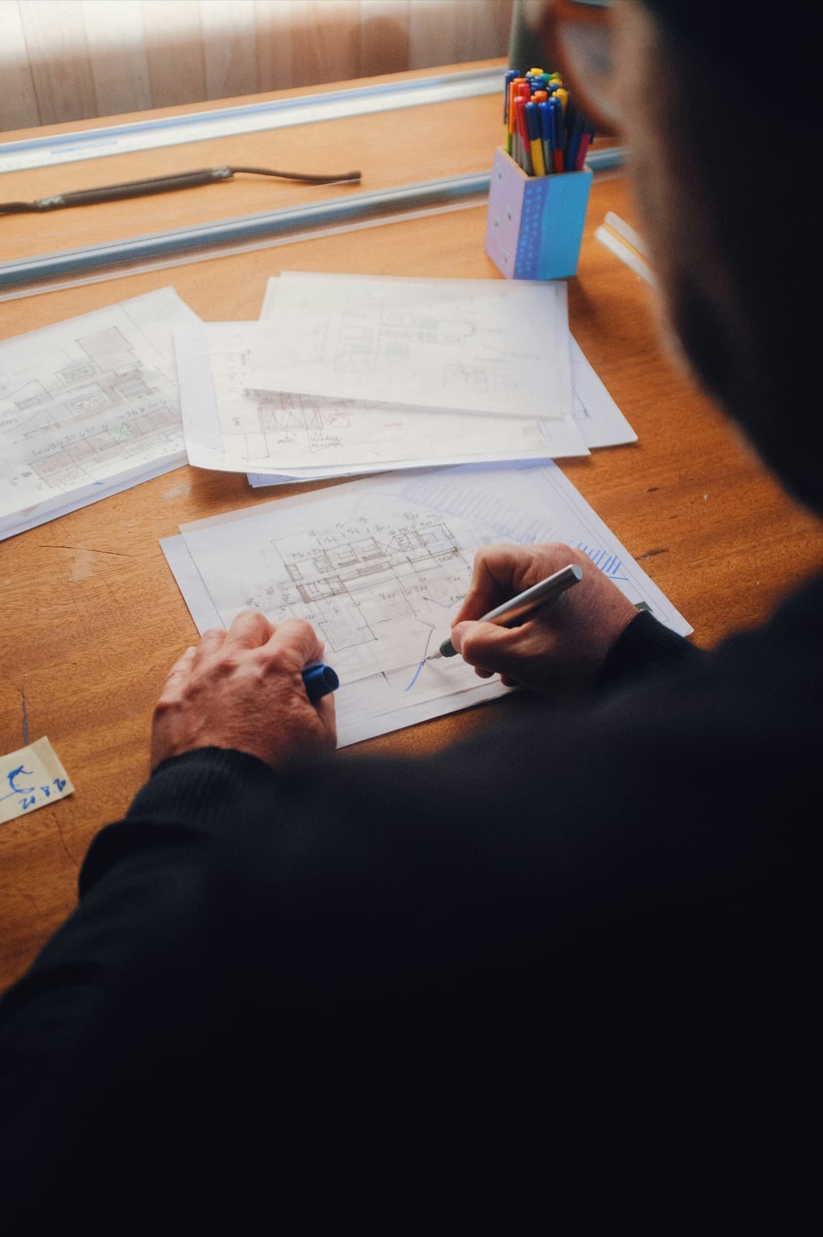 Architect sketching over blueprints during a project planning session