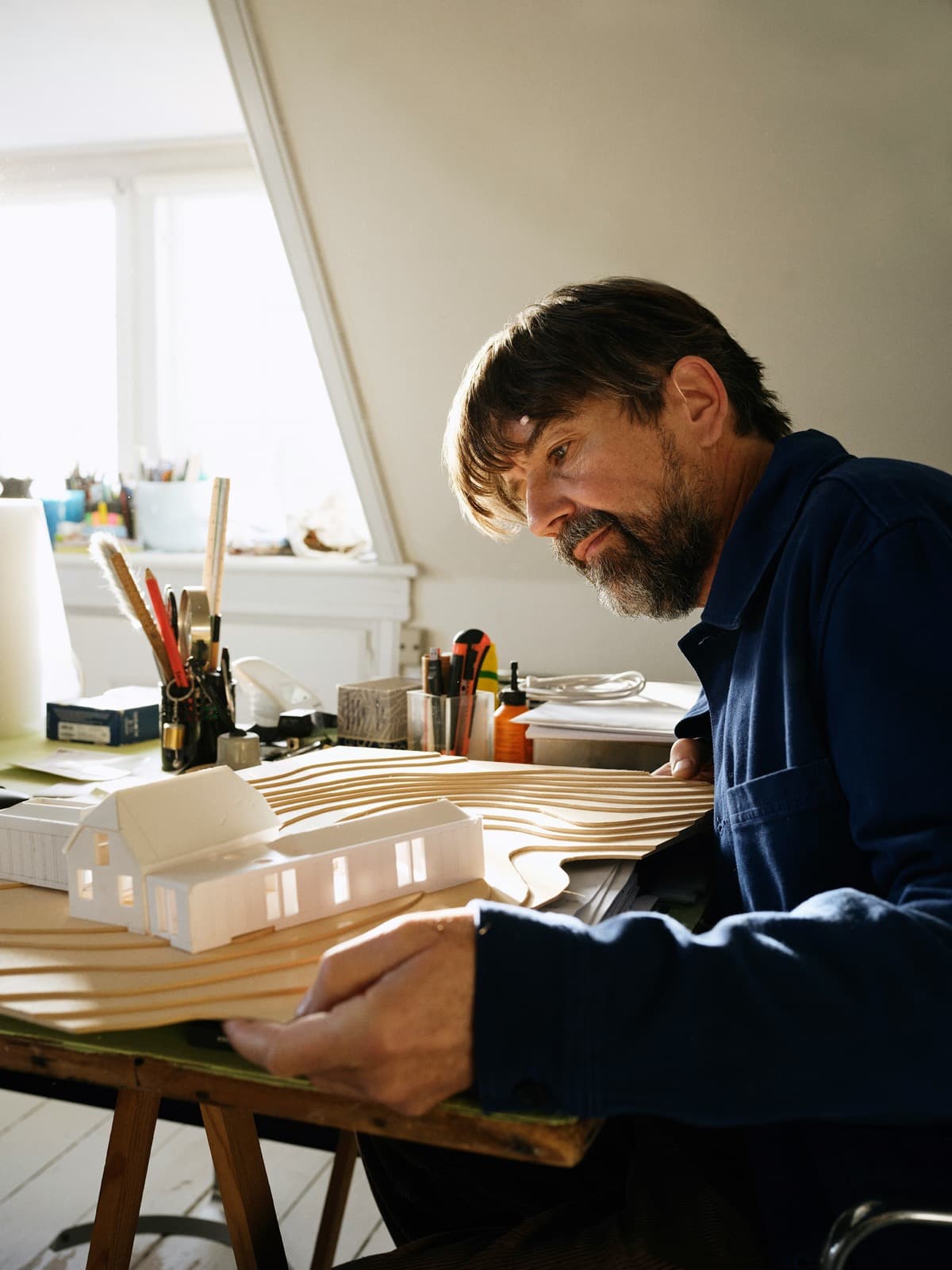 Architect reviewing a physical building model during project planning