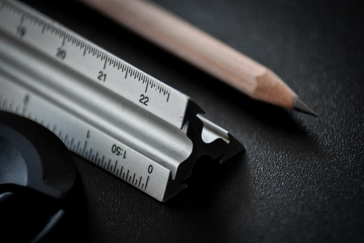 Architectural scale ruler laid across detailed plans